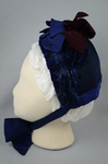 Bonnet, blue felt capote with blue velvet, blue feather trim, and velvet ribbon in blue and burgundy, 1880s, front view by Irma G. Bowen Historic Clothing Collection