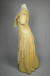 Evening gown, pale yellow faille with Chantilly lace and a bobbinet overlay appliquéd with Art Nouveau lilies, c. 1905, side view by Irma G. Bowen Historic Clothing Collection