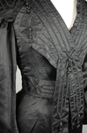 Suit, black ottoman silk trimmed with Maltese crosses and tassels of silk-wrapped beads, 1915-1917, detail of bodice front and collar by Irma G. Bowen Historic Clothing Collection