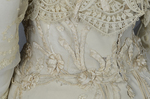 Dress, House of Rouff, cream wool with lace-draped bodice and sleeves, trimmed with cording, ribbon fronds, and roses, c. 1905, detail of waist cutaways