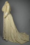 Dress, House of Rouff, cream wool with lace-draped bodice and sleeves, trimmed with cording, ribbon fronds, and roses, c. 1905, side view by Irma G. Bowen Historic Clothing Collection