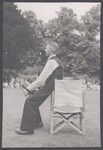 Melodeon player sitting on the arm of a chair
