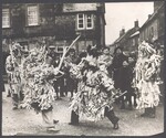 Men in Garland outfits performing sword dance