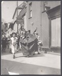 A hobby horse leading children down a street