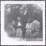 Evelyn K. Wells standing with four unidentified people by Unknown