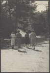 Five women walk down a shaded dirt road, 1936