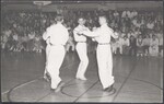 Five young men performing a sword dance for a large crowd