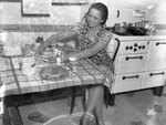 Elsie Margaret Stanton Cobb sitting at kitchen table by Unknown