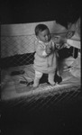 A baby in the Dietrich family standing in a crib with help from their mother in Moscow, Russia, USSR, ca. 1932-1933 by Jacobi, Lotte, 1896-1990