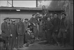 Group of primarily young men and women posed around a junk car in the USSR, ca. 1932-1933 by Jacobi, Lotte, 1896-1990